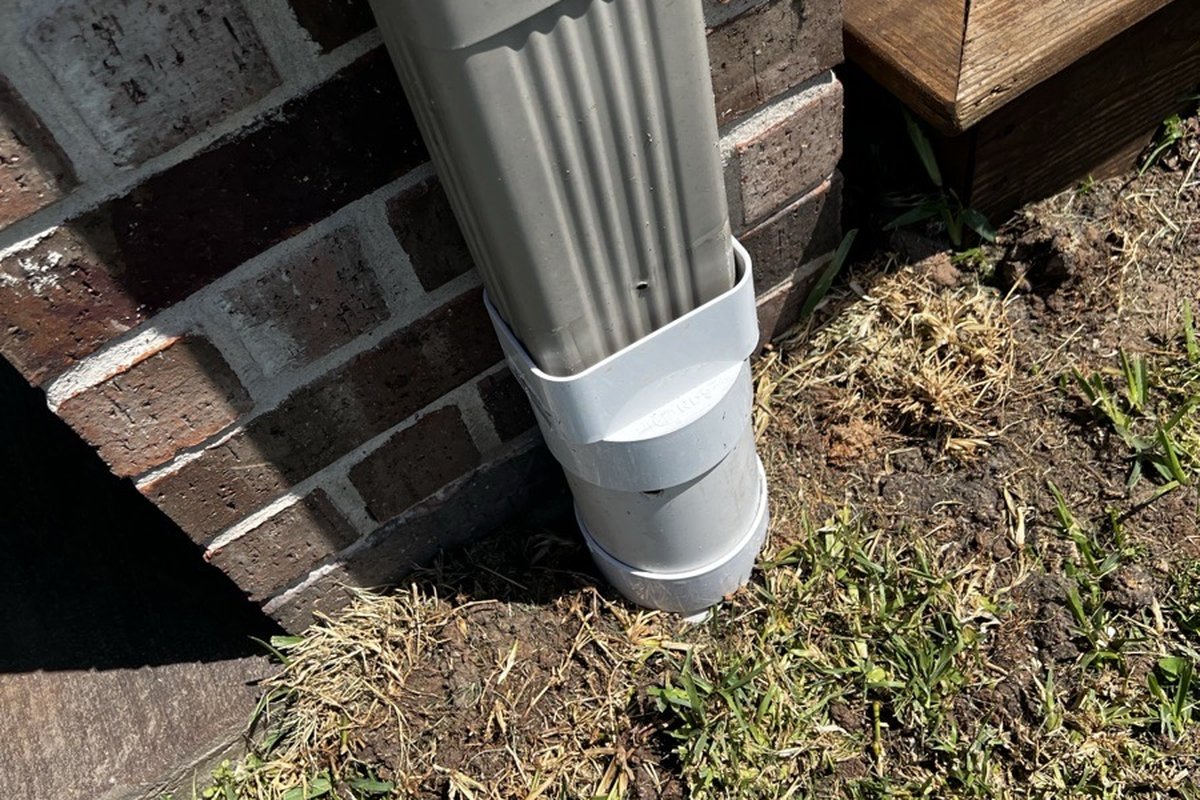 Professional PVC downspout extension installation at a Houston TX home