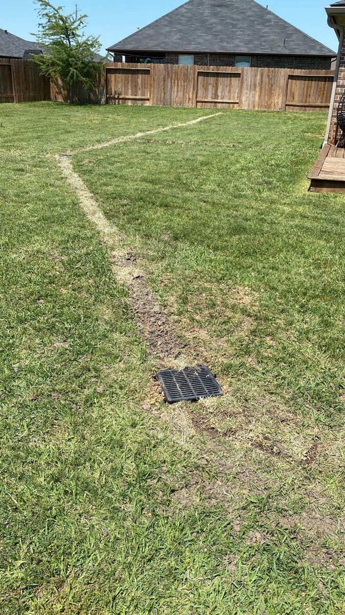 Completed yard drainage system with restored lawn at a Houston home